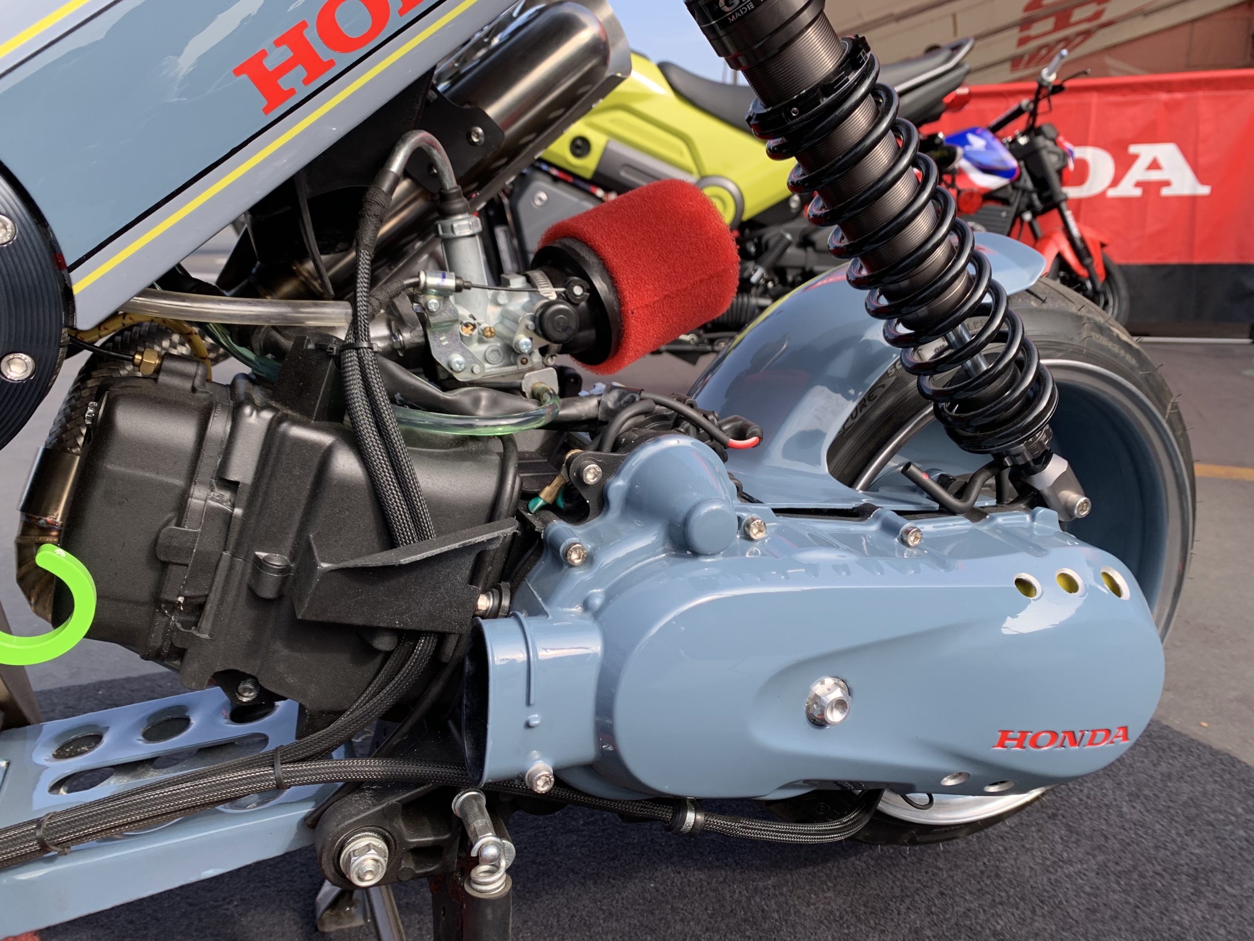 Engine and rear wheel of 2022 Honda Navi parked outdoors for IMS 2021